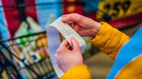 person checking a grocery receipt