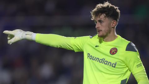 Walsall goalkeeper Sam Hornby points at his defence during a game