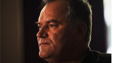 Ratko Mladić is photographed in a close up shot looking away from the camera