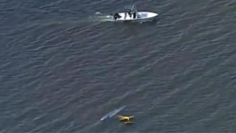 A rescue boat nears debris from a plane collision over a lake in Florida.