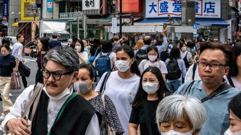 People walk across the Shibuya Crossing in Tokyo.