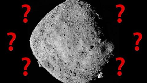 A silver asteroid against a black background surrounded by question marks