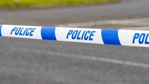 A close-up of a police tape on a road
