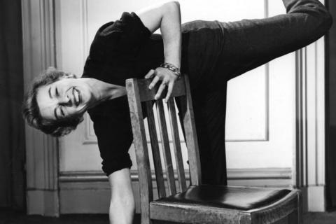 Eileen Fowler demonstrates a warm- up exercise with a chair