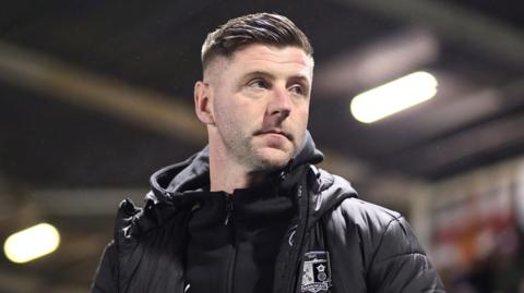 Paul Gallagher looks on from the touchline during his unsuccessful five-match spell in charge of Barrow at the start of the year