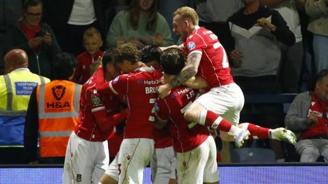 Kieffer Moore is mobbed by Wrexham team-mates