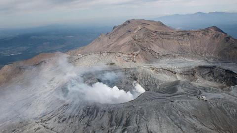 White smoke billows out of crater of massive volcano