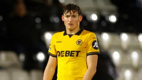 Fletcher Holman standing on the pitch with his arms by his side during a match for Wolves under-21s