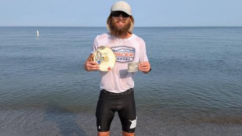 Kelly holds his winner's awards beside Lake Erie after breaking the Buckeye 200 course record and jumping into the water at the finish