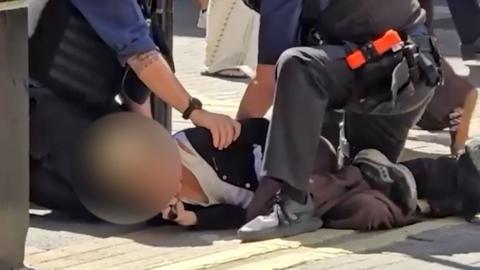 Woman on the floor being arrested.