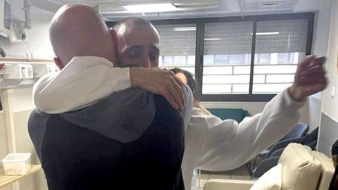  Eli Sharabi and Steve Brisley hugging in a hospital in Israel.