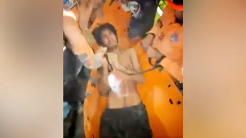 A 21-year-old man being pulled from rubble in Venezuela's La Guaira state