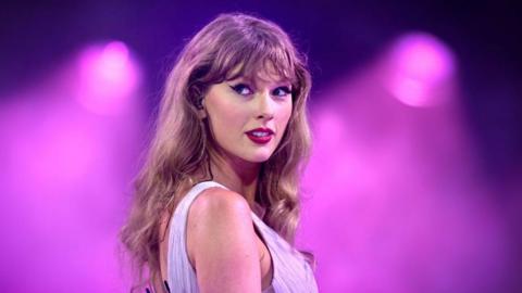 Taylor Swift with a magenta background