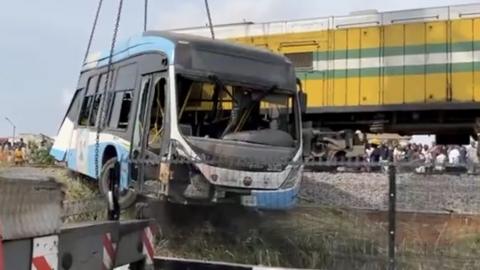 A wreckage of the bus being removed from the rail track