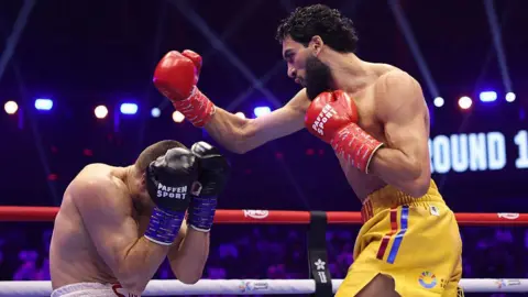 Hamzah Sheeraz throws a punch at Simon Zachenhuber
