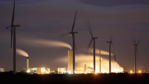 Wind turbines near chemical and manufacturing plants on the River Mersey estuary in England, 7 November 2016