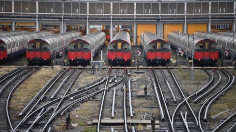 Piccadilly Line tube trains parked up symmetrically at a depot near Boston Manor with multiple rail tracks in the foreground 