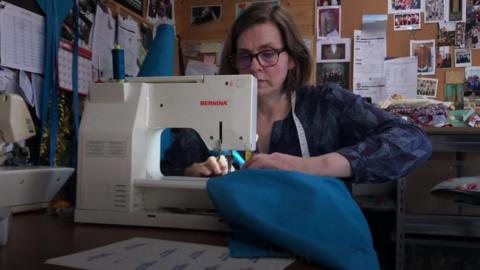 Costume maker at a sewing machine