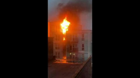 Large flames burn multiple flats in a building