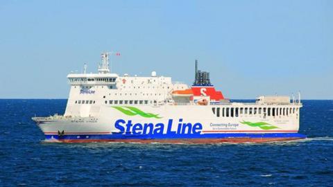 Image shows vessel Stina Vinga sailing through the sea. The large white RoPax vessel is white. It has a big blue logo which states Stena Line.