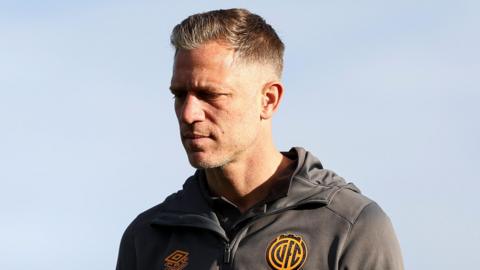 Cambridge United captain Michael Morrison standing outside wearing training wear