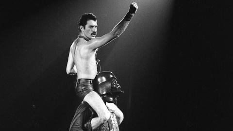Freddie Mercury sits on the shoulders of Star Wars character Darth Vader during The Game Tour on 20 September 1980