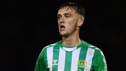 Jamie Andrews in action for Yeovil Town. He is wearing a green and white striped shirt.