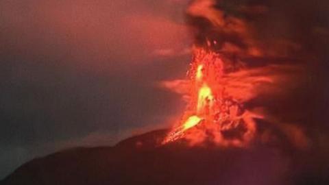 A red flash of lava above the erupting Mount Ruang, an Indonesian volcano