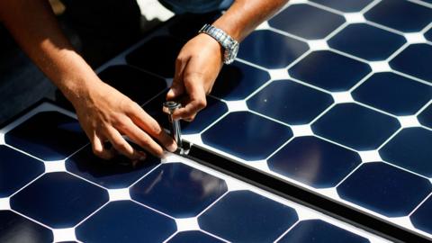 Hands installing solar panels