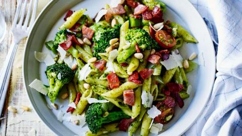 Bacon and broccoli pasta salad in a white dish.