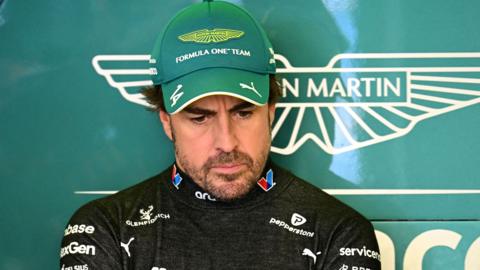 Fernando Alonso stood in the Aston Martin garage at the Australian Grand Prix
