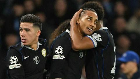 Joao Pedro celebrates with Chelsea's French defender Wesley Fofana and Chelsea's Argentinian midfielder Enzo Fernandez after scoring his team's third goal against Napoli