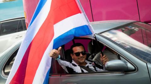 A person celebrates with the flag of Costa Rica from a car during Presidential Elections on February 6, 2022 in San Jose, Costa Rica.