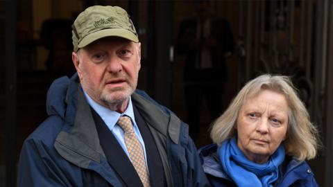 Alan Bates, founder of the Justice for Sub-postmasters Alliance, left, with his wife Suzanne Sercombe, speaks to members of the media after giving evidence in the Post Office Horizon IT public inquiry in London, UK, on 9 April 2024