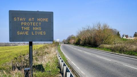 Stay home, save live road sign