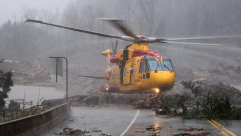 Royal Canadian Air Force helicopter hovering over storm damage