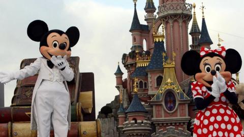 Mickey and Minnie Mouse costumes are pictured outside of Disneyland castle in 2005