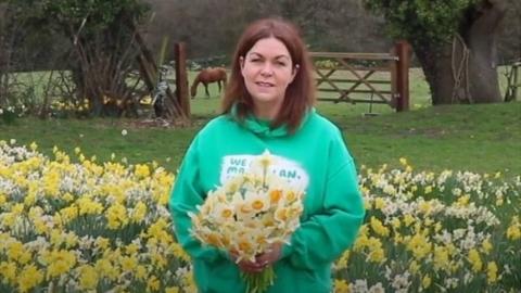 Gail Jackson holding a bunch of daffodils