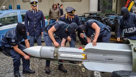 Italian police with missile seized in raids on far-right groups