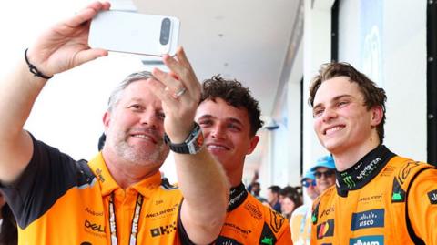 McLaren CEO Zak Brown takes a selfie with drivers Lando Norris and Oscar Piastri after the Miami Grand Prix