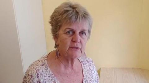 Alison Theaker stood in her utility room looking straight at the camera. She is stood in her kitchen and has an annoyed look on her face.