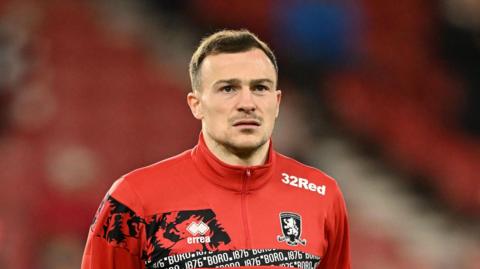 George Edmundson, wearing a Middlesbrough tracksuit, warming up for a game