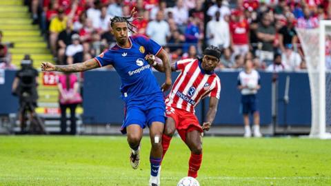 Manchester United defender Leny Yoro battles for possession with Ademola Lookman