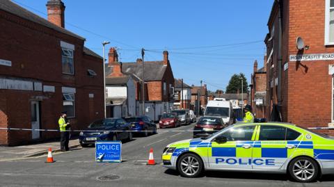 A police cordon at the entrance to a road