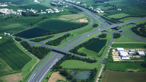 An artists impression of what the finished Black Cat road scheme could look like, with a fly-over, lots of lanes of traffic, green fields, either side and buildings around the road.