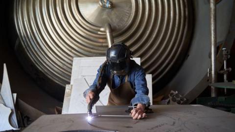 A worker cuts a stainless steel sheet at a steel manufacturing facility in Mexico City, Mexico, on Thursday, Feb. 6, 2025.