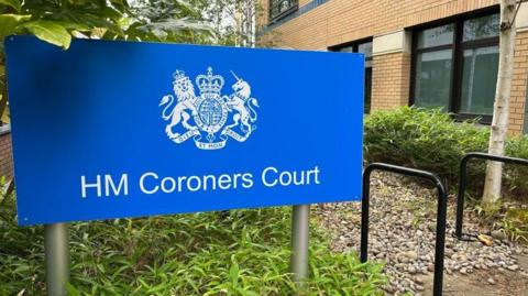 A blue sign with HM Coroners Court written on it. 