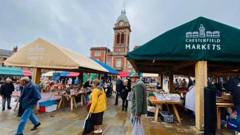 Chesterfield Market, showing substantial, wooden framed stalls with a municipal building behind