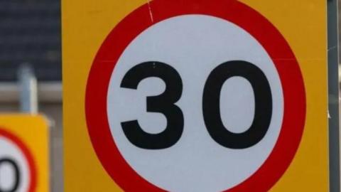 the number 30 on a white circular background, with a red rim and and a futher yellow backfound