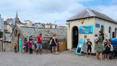 People queuing at a fishmonger's in Tenby